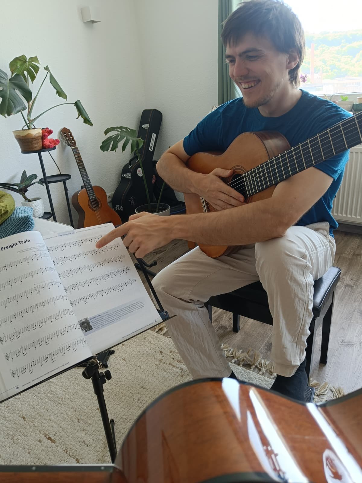 Andreas Busemann gibt Gitarrenunterricht in Würzburg und erklärt eine Stelle in den Noten